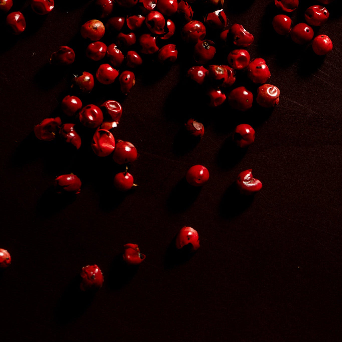 Red berries scattered on a dark surface