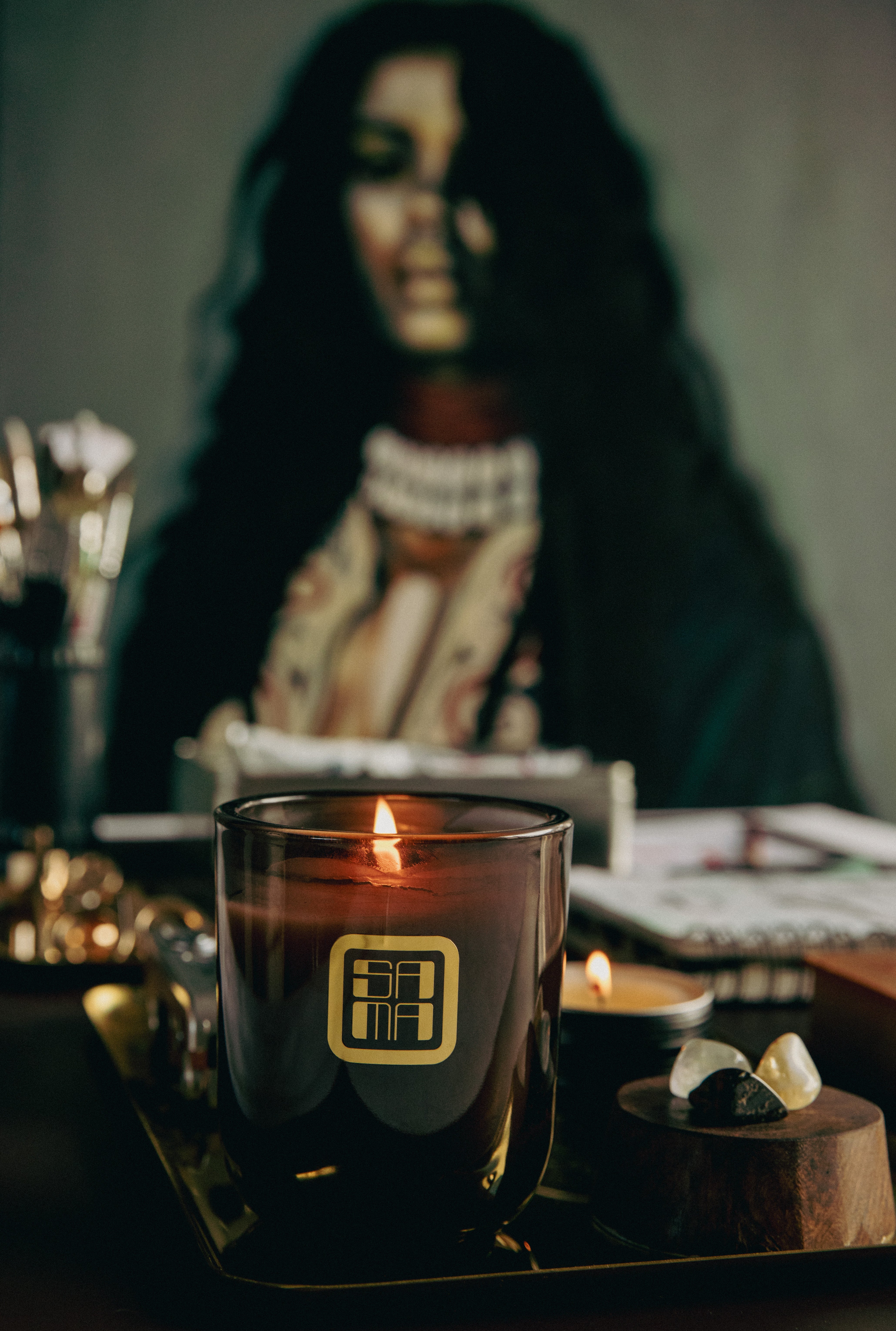 Candle in a glass holder with a blurred figure in the background