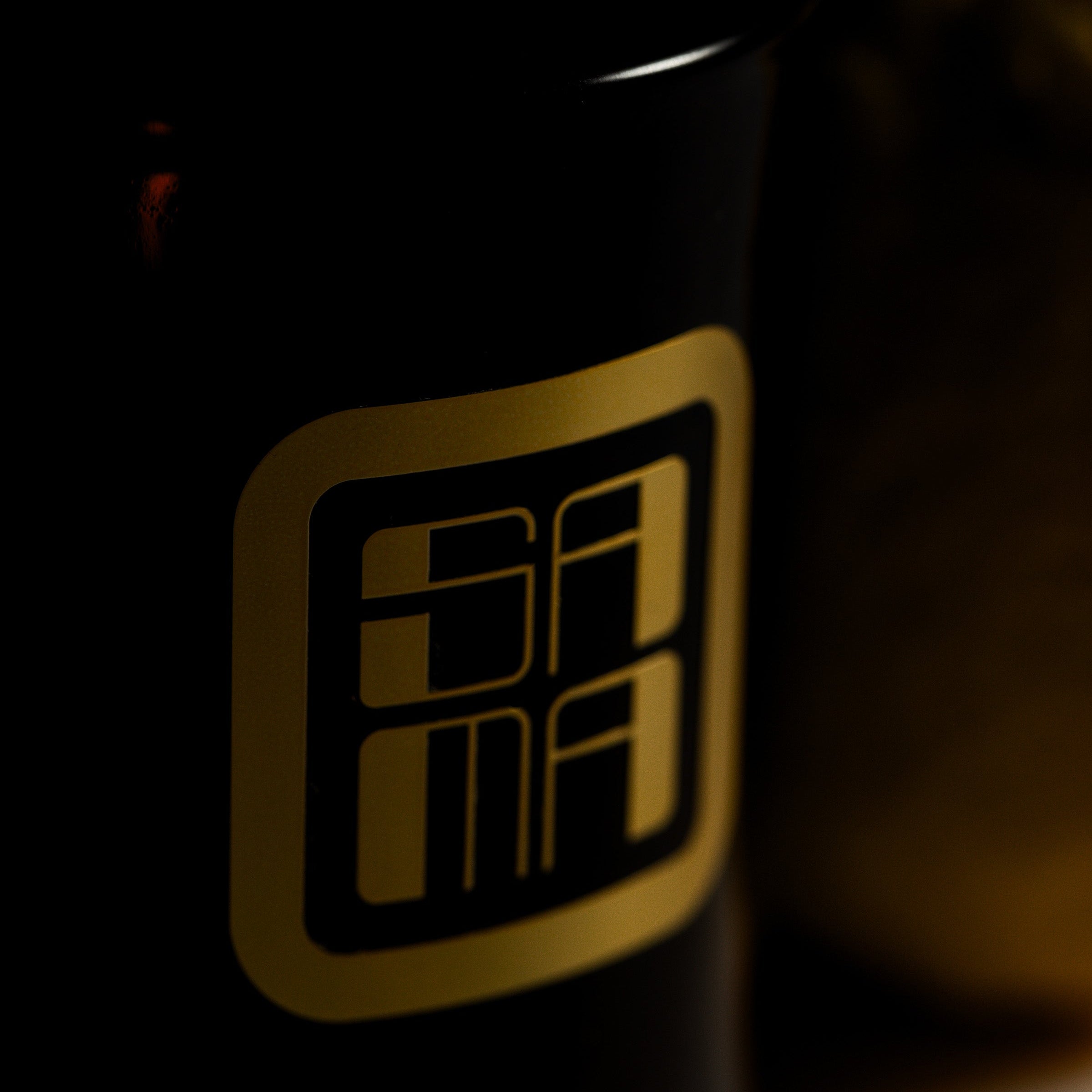Black container with gold logo on a dark background