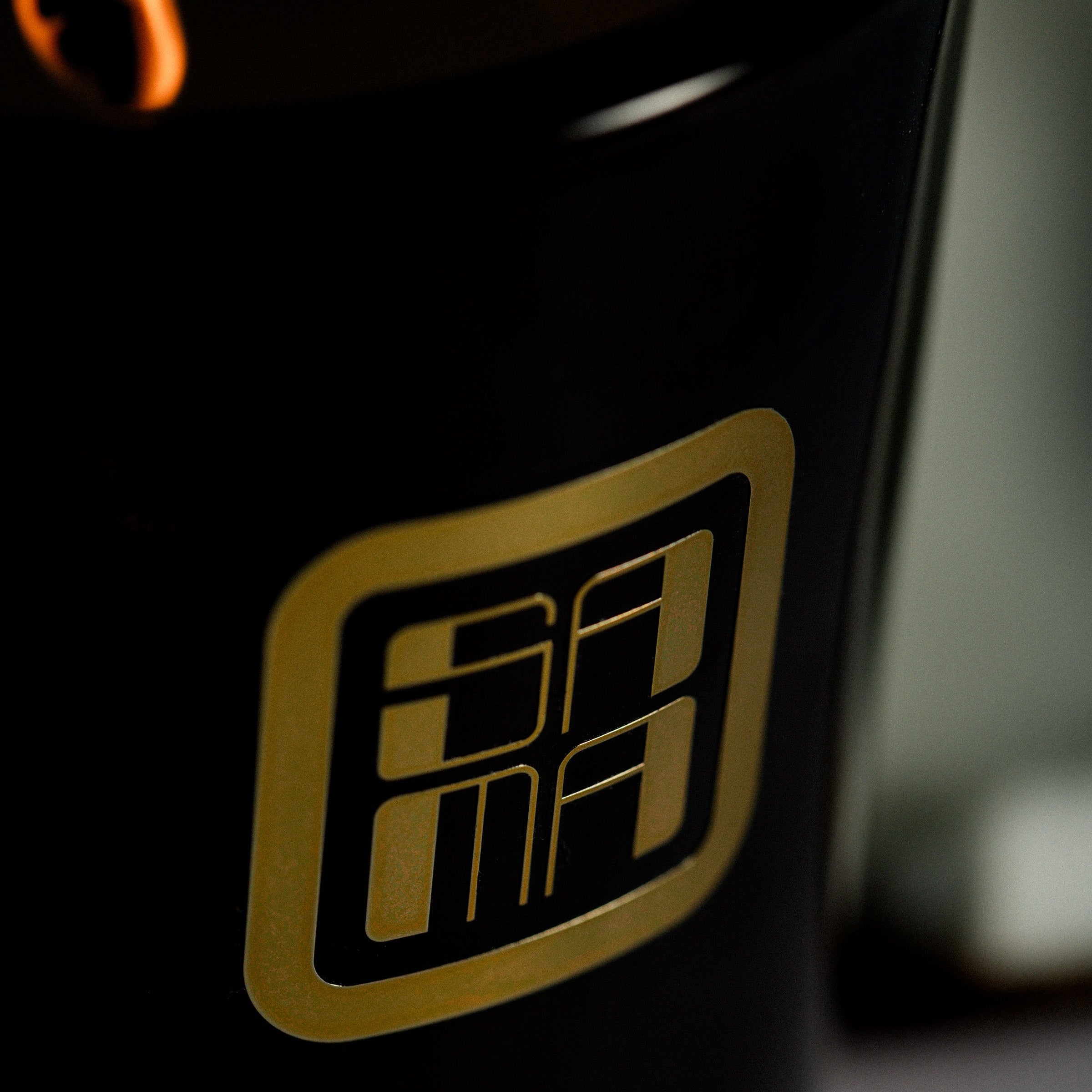 Black container with a gold logo featuring the letter 'A' on fire.